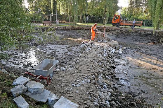 Bauhofmitarbeiter Siegfried Gebhardt bei Stemmarbeiten am Betonsockel der alten Wasserfontäne im ausgepumpten Teich im Bernhard-Bauer-Park in Wickede. FOTO: ANDREAS DUNKER 