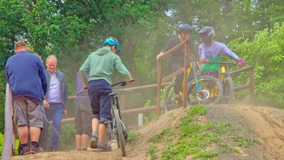 Ein Problem zeigte sich bereits bei der Eröffnung des Bike-Parks der Gemeinde Wickede (Ruhr) am Samstag: die erhebliche Staub-Entwicklung auf dem Start-Hügel. Der Wind trieb die dreckige Wolke in Richtung des kommunalen Freibads. Provisorisch wurde die Erde aus Flaschen mit Wasser benetzt. Auf Dauer sollen hier Gießkannen oder Schläuche zum Einsatz kommen, um Ärger mit der Nachbarschaft zu vermeiden. FOTO: ANDREAS DUNKER