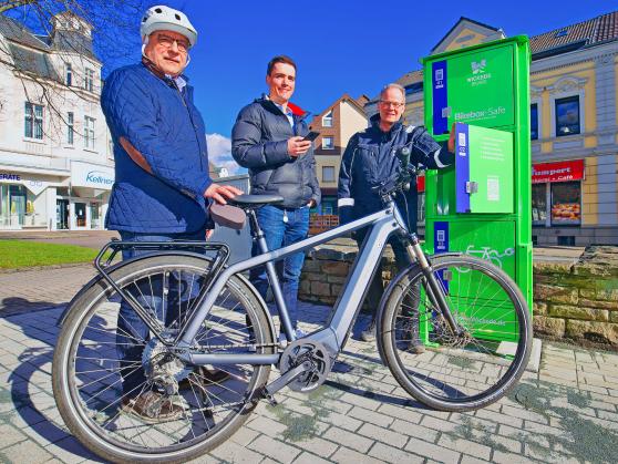 Stadtraum-Geschäftsführer Stefan Dittrich und sein Mitarbeiter Steffen Kampmeier sowie Bürgermeister Dr. Martin Michalzik (CDU) am heutigen Donnerstag bei der Inbetriebnahme der neuen E-Bike-Akku-Ladeboxen am Marktplatz in Wickede. FOTO: ANDREAS DUNKER