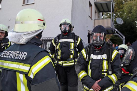 Feuerwehrleute mit schwerem Atemschutz vor dem Wohnhaus FOTO: ANDREAS DUNKER