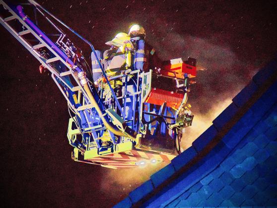 Unter Atemschutz bekämpfte ein Team aus dem Korb der Drehleiter den Kaminbrand von oben.  FOTO: ANDREAS DUNKER