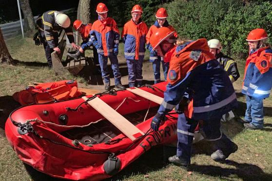 Die Jugendfeuerwehr bei der Inbetriebnahme eines Schlauchbootes in der Dunkelheit. FOTO: FEUERWEHR