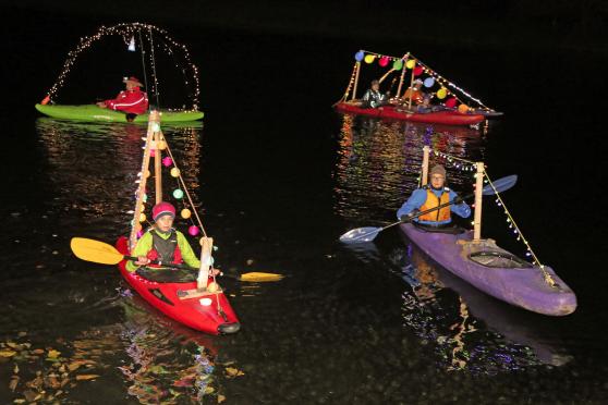 Die dritte "Lampionfahrt" des Wickeder Kanu-Clubs auf der Ruhr: die bunt beleuchteten Boote spiegeln sich im dunklen Flußwasser. FOTO: ANDREAS DUNKER