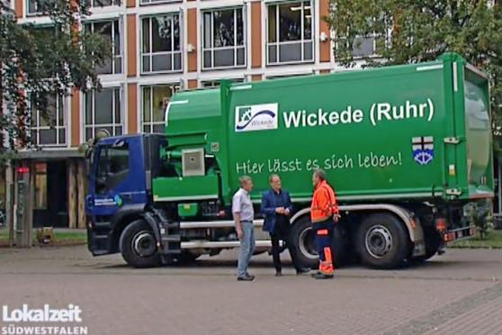 Abfallbeseitigung rekommunalisiert: Ludger Böhmer als zuständiger stellvertretender Fachbereichsleiter der Gemeindeverwaltung, Bürgermeister Dr. Martin Michalzik (CDU) und ein Müllwerker mit einem Sammelfahrzeug des "KommunalService' Wickede-Fröndenberg" vor der WDR-Fernsehkamera. FOTO: WDR