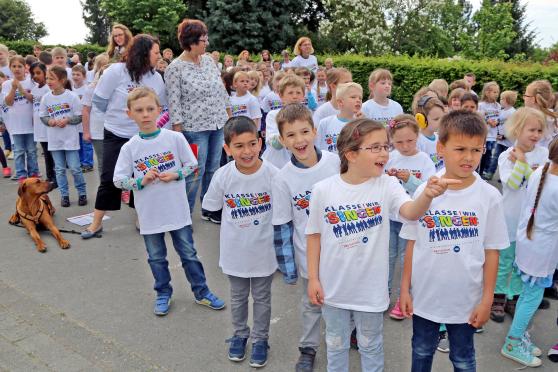 Feuerwehr-Übrung: Kinder und Leher der Melanchthon-Grundschule auf dem Schulhof – teils schon mit ihren T-Shirts für den morgigen Auftritt bei "Klasse! Wir singen" in der Westfalen-Halle in Dortmund. FOTO: ANDREAS DUNKER