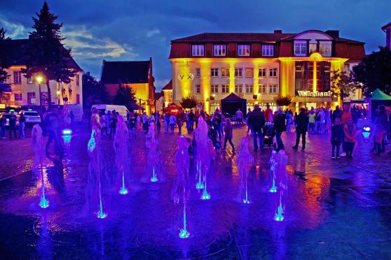 Die farbig illuminierten "Stadt-Quellen" auf dem Werler Marktplatz – im Hintergrund: das "Alte Rathaus" mit Musikschule und die Geschäftsstelle der Volksbank Hellweg FOTO: ANDREAS DUNKER