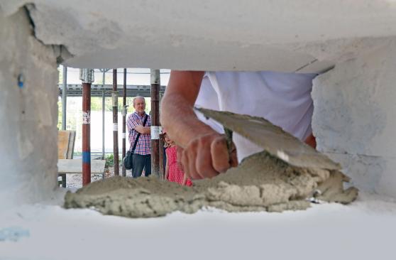Mit frisch angerührtem Mörtel wird die Kupferkapsel in die Wand eingemauert. FOTO: ANDREAS DUNKER