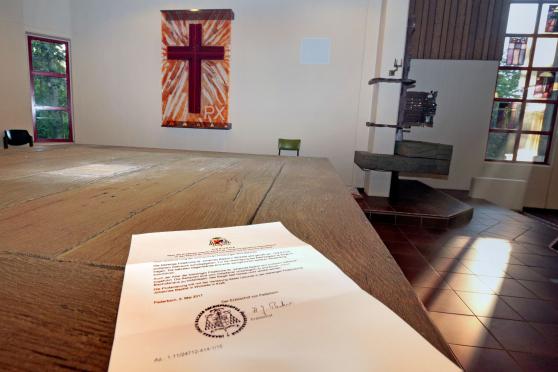 Die bischöfliche Profanierungsurkunde liegt für ein Foto auf dem leeren Altar. FOTO: ANDREAS DUNKER