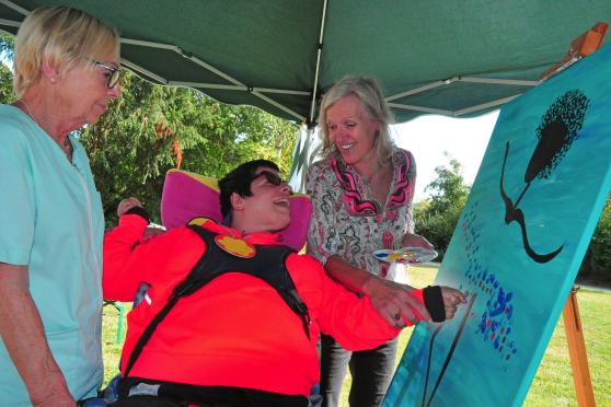 Künstlerin Sabine Rammelmann aus Fröndenberg (rechts) leitet Patientin Andrijana Celebic an, mit ihren Fingerabdrücke das farbige Kunstwerk mitzugestalten. Links: Ruhrtalklinik-Mitarbeiterin Birgit Jovic. FOTO: DOMINIK PIEPER