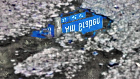 Die Fahrbahndecke an der Straße "Am Graben" ist in einem desolaten Zustand. In den Schlaglöchern sammelt sich das Regenwasser. – Unsere Aufnahme zeigt die Spiegelung des Straßenschildes in einer solchen Pfütze. FOTO: ANDREAS DUNKER