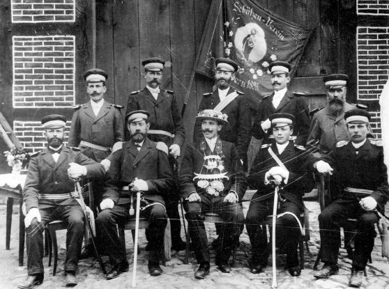 Das älteste Bild des Vereins zeigt Vorstand und König im Jahre 1903/04. Der König regierte zu der Zeit noch ohne Königin. Die Aufnahme wurde bei Bauer Goeke in Wimbern gemacht. Vor der Deelentür die Fahne von 1893; (hintere Reihe, von links): Wilhelm Sturzenhecker (Oesbern), Heinrich Schulte (Werringsen), Franz Knieper (Wimbern), Josef Schüpstuhl (Wimbern), Franz Brune (Brockhausen); (vordere Reihe): Josef Coerdt gen. Nadermann (Wimbern), Anton Goeke (Wimbern/Oberst und Gemeindevorsteher), Heinrich Beringhoff (König), Josef Goeke (Wimbern), Max Stratmann (Bellingsen) ARCHIVFOTO: PRIVAT
