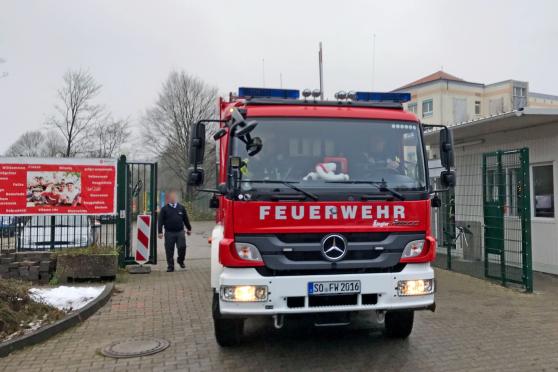 Wir lassen uns von solchen vermeintlichen "Ordnungshütern", die offenbar die deutschen Gesetze nicht richtig kennen, allerdings weder abwimmeln noch einschüchtern und gehen unserer freien journalistischen Arbeit und Bildberichterstattung natürlich trotzdem nach: Hier das geplante Foto vom Feuerwehr-Fahrzeug vor der ZUE in Wimbern. – Schlimm, dass hilflose Flüchtlinge in der Einrichtung wohl der Willkür solcher Sicherheitsleute ausgesetzt sind. Der Misshandlungsskandal in der Flüchtlingsunterkunft in Burbach ist ein abschreckendes Beispiel dafür, wenn Bezirksregierung oder Betreuungsverbände solche Sicherheitsleute beauftragen und sie nicht in ihre Schranken weisen. FOTO: ANDREAS DUNKER