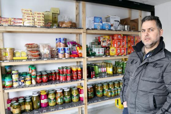 Ein Verkäufer vor einem Warenregal mit teils arabischen Lebensmitteln  FOTO: ANDREAS DUNKER