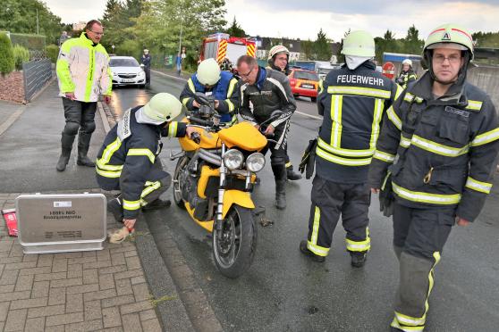 Das schwere Motorrad der Marke "Triumph" drohte im wahrsten Sinne des Wortes zum "Feuerstuhl" zu werden. Denn an der Batterie des Motors hatte es einen technischen Defekt gegeben und unter dem Fahrersitz begann es schon zu qualmen. – Zu Hilfe gerufene Wickeder Feuerwehrleute unterstützten den Motorradfahrer aus dem Ennepe-Ruhr-Kreis schließlich bei der Verhinderung einer möglichen Brand- oder Explosionsgefahr sowie der Bewahrung vor weiterem Schaden. FOTO: ANDREAS DUNKER