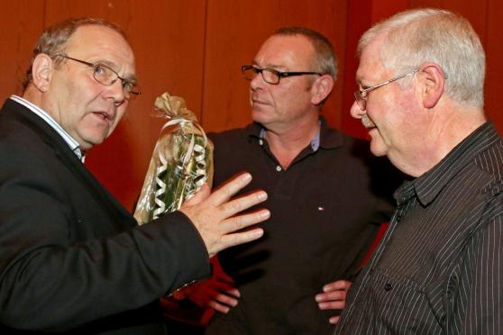 VHS-Leiter Wolfgang Klesse bekam zum Abschied von den Bürgerhaus-Hausmeistern Günter Gutland und Kevin Cheshire einen guten Tropfen aus der Ruhrgemeinde (von links). FOTO: ANDREAS DUNKER