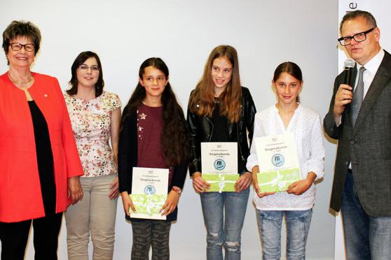 Vizelandrätin Irmgard Soldat und Kathrin Müller als Chefin des Medienzentrums mit den Siegern im Schreibwettbewerb der Altersgruppe 10 bis 12 Jahre: Johanna Scheibe (1. Platz) und Jolanda Kaiser (3. Platz) sowie Lena Fischer (2. Platz) aus Wickede (Ruhr) (von links). Rechts: Moderator Ulli Potofski. FOTO: ANDREA KERKHOFF / KREIS SOEST