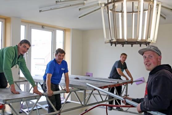 Die Mitarbeiter der Wickeder Bedachungsfirma ROTEK bauen heue Mittag das Gerüst über der Wendeltreppe im Rathaus auf und schaffen damit eine Arbeitsbühne für die anderen Gewerke (von links): Denis Lange, Chef Christian Stobbe, David Trautmann und Sebastian Bußmann. FOTO: ANDREAS DUNKER