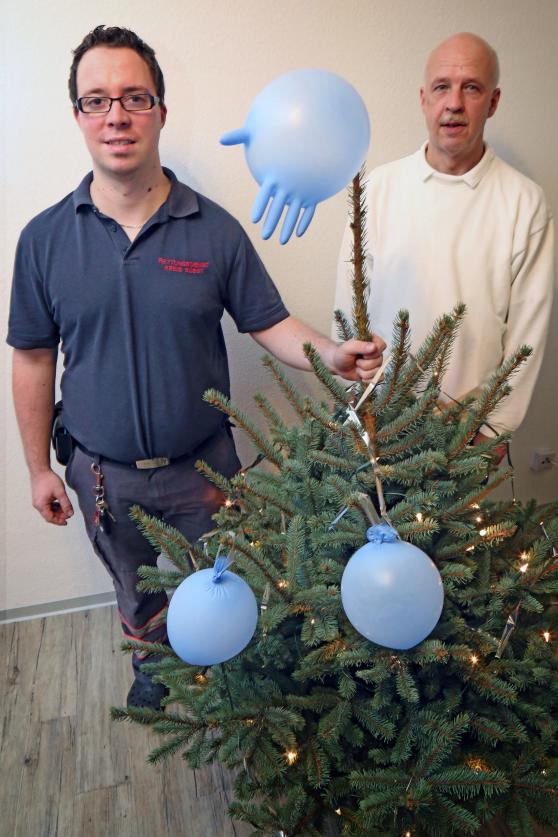 Mit kurios geschmücktem Weihnachtsbaum: Rettungsassistent Denis Baier (28) aus Arnsberg sowie Chirurg und Notfallmediziner Dr. Michael Körber (58) aus Köln beim Bereitschaftsdienst am Wimberner Notarzteinsatzfahrzeug-Standort des Rettungsdienstes des Kreises Soest. FOTO: ANDREAS DUNKER