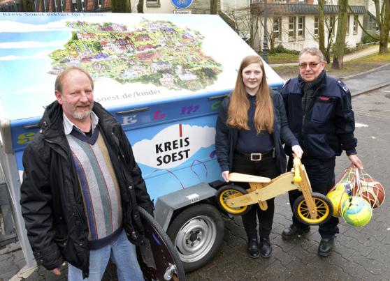 Feuerwehrfrau und Erzieherin Doreen Schaefer sowie Gemeindebrandinspektor Georg Ptacek (von rechts) von der Freiwilligen Feuerwehr Wickede (Ruhr) haben das Spielmobil des Kreises Soest schon für eine Veranstaltung in Wickede abgeholt. Die Übergabe des mit Spielgeräten aller Art beladenen Pkw-Anhängers erfolgte durch Werner Müller (links) vom Fachberatungsteam Jugendbildung und Jugendförderung des Kreises Soest. FOTO: THOMAS WEINSTOCK / KREIS SOEST