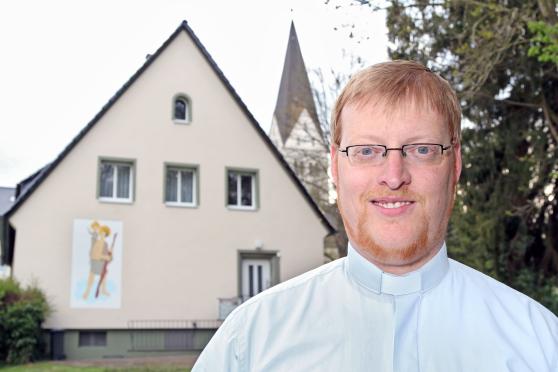 Vikar Alexander Plümpe vor der Vikarie – dem Wohnhaus des Priesters – mit der katholischen St.-Antonius-Kirche im Hintergrund ARCHIVFOTO: ANDREAS DUNKER