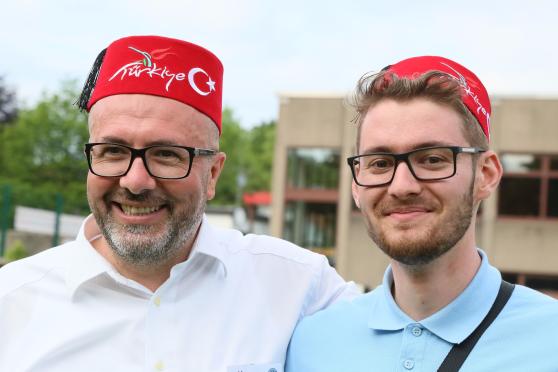 Mit dem roten "Fez" als traditioneller türkischer Kopfbedeckung waren die Los-Verkäufer für die große Tombola gut zu erkennen – wie hier Umut Cetin (rechts). – Auch der türkischstämmige Wickeder Unternehmer Veli Güngör als Mitorganisator und Sponsor des Festes machte sich den Spaß und setzte einen solchen Hut für ein Pressebild auf. FOTO: ANDREAS DUNKER