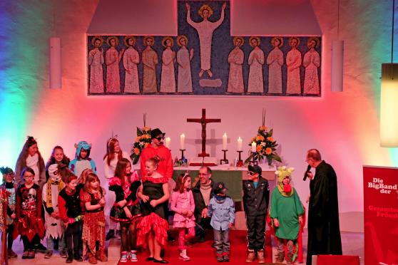 Pfarrer Dr. Christian Klein präsentierte beim Karnevalsgottesdienst die bunt kostümierten Kinder und Jugendlichen im Chorraum der evangelischen Christus-Kirche in Wickede. FOTO: ANDREAS DUNKER